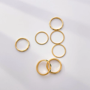 Detailed set of 7 gold rings featuring green gemstones and minimalist band designs