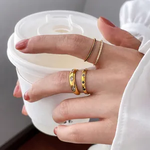 Gold-plated ring set featuring marquise zircon and black gems on model holding coffee cup