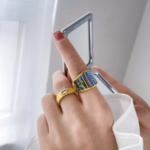 Detailansicht des Goldrings mit Muschelstreifen und Wellenband mit grünem Zirkon