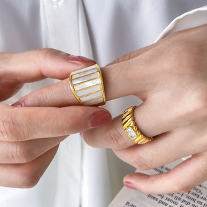 Goldener breiter Ring mit Muscheleinlagen und Wellenring mit grünem Zirkonia Stein