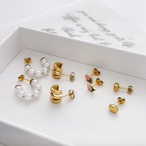 Elegant 4-piece gold earring set featuring pearls, C-hoops, and pink tulip floral studs