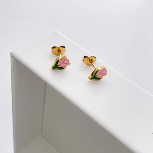 Close-up of elegant tulip stud earrings with pink enamel petals and gold finish