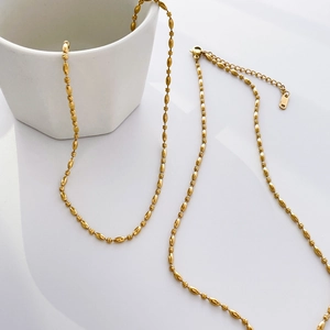 Detail of 14K gold plated titanium chain with oval beads and small metal tag