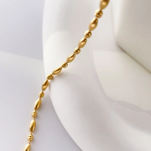 Detail of 18k gold plated stainless steel chain with oval and round beads