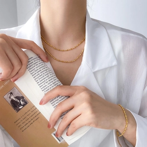 Close-up of double-layer gold bead necklace and matching bracelet on a model