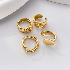 Set of four gold geometric titanium steel rings with twisted and layered line designs