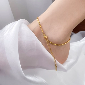 Close-up of golden beaded anklet with lobster clasp and adjustable extension chain