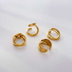 Detailed view of four minimalist 18K gold plated titanium steel rings with geometric patterns