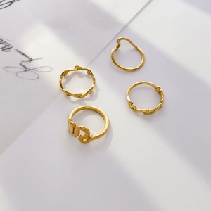 Detail of four-piece gold ring set featuring wave patterns and leaf textures