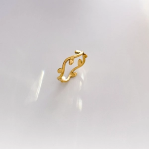 Detailed view of the gold-finish open ring featuring abstract olive leaf motifs