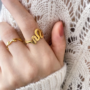 Chic gold abstract seagull and wavy leaf ring set worn on finger with knit sweater