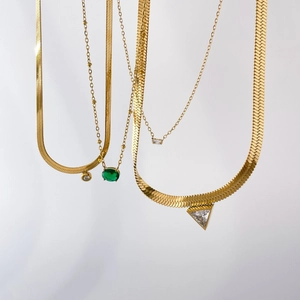 Layered gold chain necklace set with green oval emerald and geometric zircon pendants