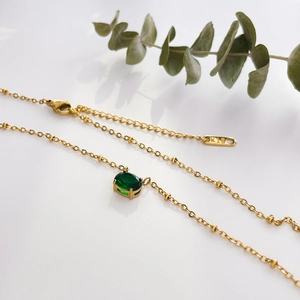 Detail of 18K gold chain necklace with green oval gemstone and K18 hallmark tag