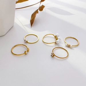Five-piece gold ring set featuring freshwater pearls, zircons and twist band designs