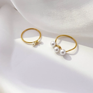 Detail of freshwater pearl gold rings with twisted band and sparkling zircon inlay