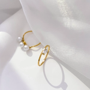 Detailed macro shot of elegant gold ring set with rectangular zircon and white pearls