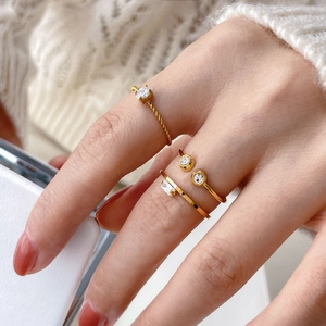 Detailed shot of three gold twist rings with small diamonds worn on a woman's finger