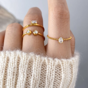 Three-piece gold ring set with freshwater pearls and zircon on a soft knit background