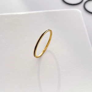Macro shot of minimalist gold textured band ring with black enamel inlay detail