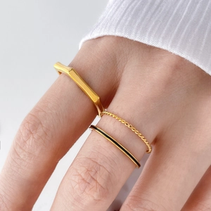 Three-piece gold ring set featuring geometric band, twisted rope, and black enamel detail
