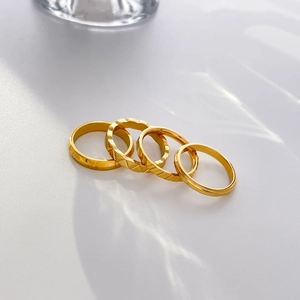 Set of four 18K gold plated titanium steel rings with Roman numerals and geometric textures