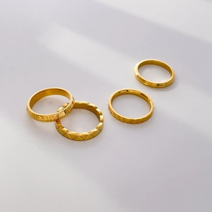 Set of four 18K gold plated titanium rings with Roman numerals and quilted textures