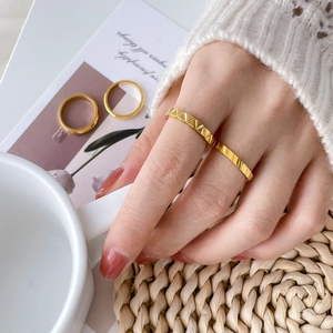 Detail of 18K gold plated titanium rings with geometric triangle and diagonal texture