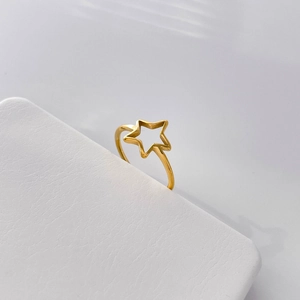 Detailed view of hollow star ring in 18k gold plated titanium steel on a display stand