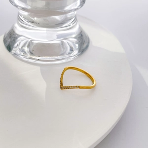 Détail macro d'une bague en chaîne plaquée or 18 carats en forme de V sertie de zircons