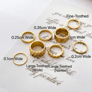 Detail view of various widths of gold gear rings displayed on white decorative card