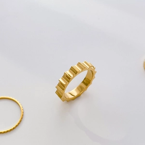 Detailed view of stackable gear design ring with 18K gold plated titanium steel finish