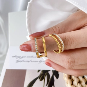 Détail de trois bagues empilables plaquées or 18 carats avec zircons et design torsadé