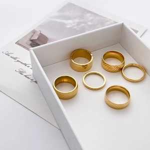 6-piece gold titanium steel ring set with hammered and textured finishes in a display box