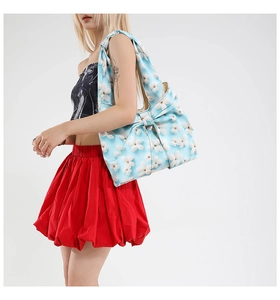 Light blue floral cotton tote bag with a large decorative bow carried by a model