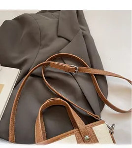 Detail of adjustable leather strap and silver buckle on a litchi grain bucket bag