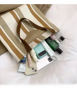 Top view of striped canvas tote bag showing spacious interior with tablet and cosmetics