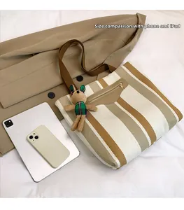 Detailed size comparison of the striped canvas tote bag with a tablet and smartphone