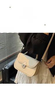 Detailed view of cream crossbody bag featuring woven texture and silver round buckle closure