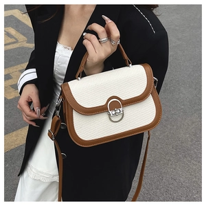 Detailed close-up of woven texture and brown leather trim on a retro crossbody bag