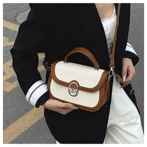 Detail of vintage patchwork crossbody bag with textured fabric and leather handles