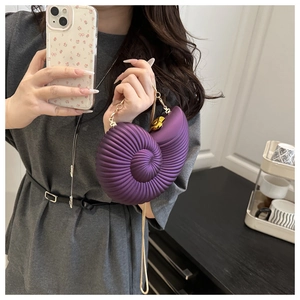 Detail of purple nautilus-shaped handbag with spiral texture and gold chain strap