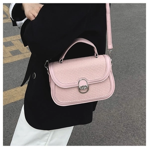 Detailed view of pink crossbody bag with woven texture on flap and silver clasp buckle