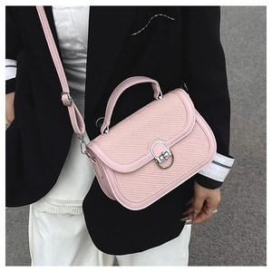 Close-up of pink woven texture handbag with silver clasp and detachable strap on a model