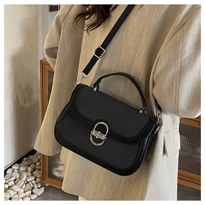 Detail of black woven crossbody bag featuring a silver oval metal twist lock and strap