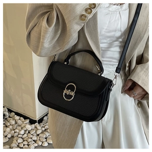 Crossbody view of a black leather and woven patchwork small square bag with gold lock