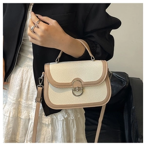 Close-up of vintage beige woven handbag with tan leather trim and silver metal lock