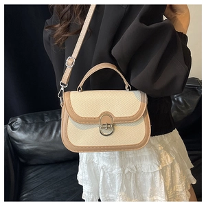 Detail of vintage woven crossbody bag featuring a metal twist lock and brown leather trim