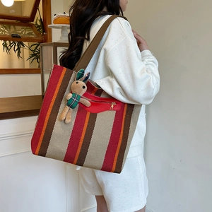 Large striped woven tote bag with shoulder straps and cute bunny doll accessory