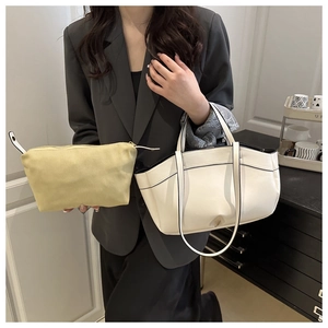 Close-up of white tote bag and yellow inner pouch set with minimalist shoulder strap detail