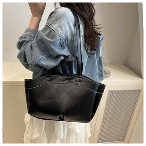 Lifestyle shot of large black tote bag with white contrast stitching and long straps